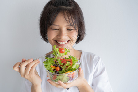 吃蔬菜沙拉的年轻女孩图片