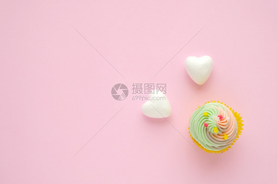 面包店粉红背景的纸杯蛋糕和白心并复制文本空间生日纪念贺卡背景平地顶视面卡片粉彩图片