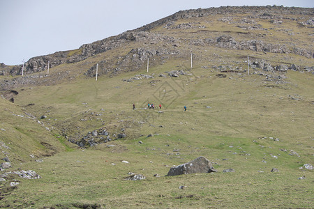 法罗群岛地貌的横向景象远山和一群无法识别的年轻人在徒步足迹上走法罗群岛光荣景象之路上Postcardmotif美丽的环境荒野图片