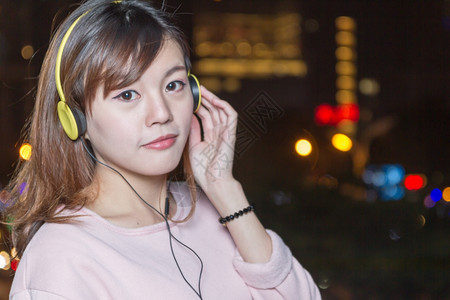 经过黑暗的女士很有吸引力的马来西亚女有黄色耳机图片