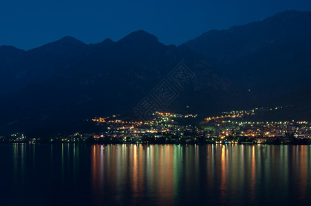 游客夜里在科莫湖对岸海的MandelloDeLario著名的山图片