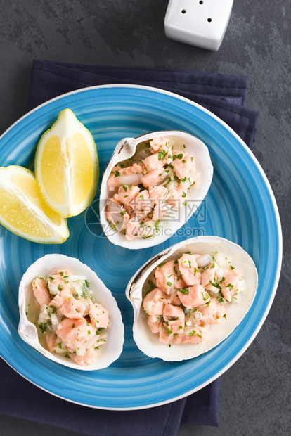粉色的传统智利新鲜自制鲑鱼肉排配有柠檬汁洋葱大蒜盐和香兰特罗在贝壳上供应拍摄智利SalmonCeviche石板上的头部图片