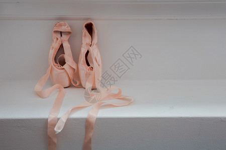 木制背景芭蕾舞女演员的足尖鞋粉色芭蕾舞木制背景芭蕾舞女演员的漂亮足尖鞋粉色芭蕾舞经典的服装丝滑图片