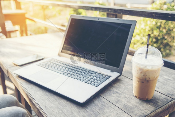 桌面药片妇女利用笔记本电脑和在木板技术概念图象上喝咖啡用笔记本电脑和智能手机空白的图片