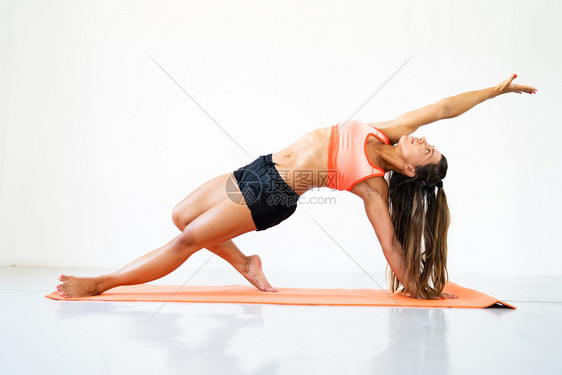 年轻女子运动健身体有氧伸展在工作室的垫子上做瑜伽锻炼白色的舞蹈普拉提图片
