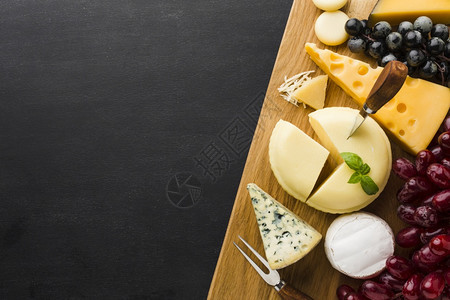 葡萄酒核桃装有复制空间的切割板上奶酪和葡萄的美食乳酪和葡萄平板瑞士图片