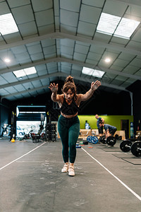 女青年在健身操场上接受地面训练习手立式运动身体锻炼绑腿图片