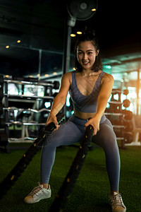 强大的力量女子用战绳在健身房锻炼概念康在身房中进行重度锻炼女图片