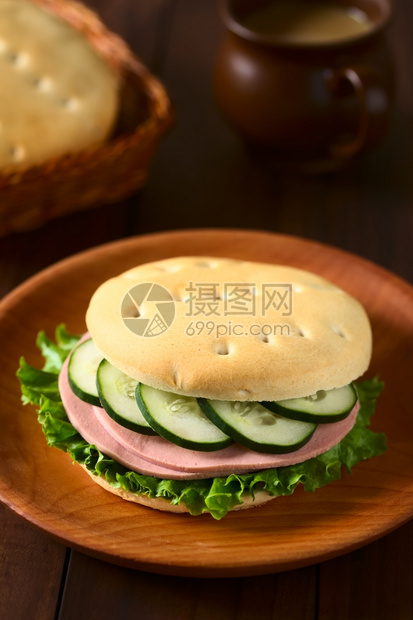 拉丁智利传统的哈鲁拉面包卷作为三明治制成配有生菜冷切和黄瓜放在木板上用自然光拍照选择焦点集中到三明治的前面来着包店食物图片