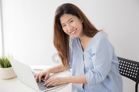 技术工作场所亚裔妇女在家中桌上用电脑笔记本概念生活方式和自我学习时穿着临服装的亚洲妇女肖像图片