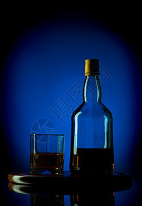 苏格兰镜子蓝底木托盘上的威士忌瓶和玻璃棕色的图片