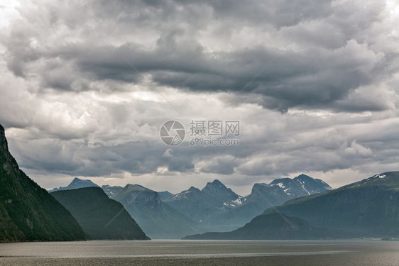 景观顶峰在多云的天空下挪威安道尔尼斯附近的Romsdalsfjorden沿线的山脉挪威安道尔尼斯附近的沿线海岸图片