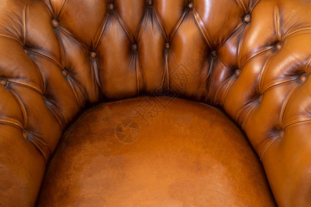 扶手椅BrownChchesterfield风格皮革抽象背景纹理手椅关闭现代设计用过的古董图片