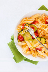 蔬菜晚餐意大利传统面食和西红柿其中含有青尼和樱桃番茄油黑胡椒从意大利面上方的薄面上看到有锌西尼和樱桃番茄白色的图片