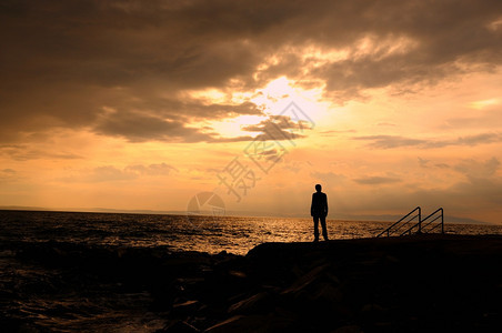 海浪天空沮丧在滩上独自站着年轻忧郁节日图片