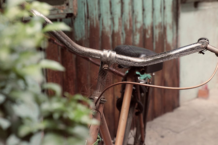 古老的令人惊叹关闭旧式自行车前门古老房子车轮生锈在越南城镇以古代语调为模糊背景损坏古董印象图片