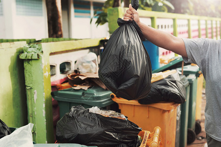 打扫能够妇女用手把垃圾装在黑袋里清洁成垃圾阳光图片