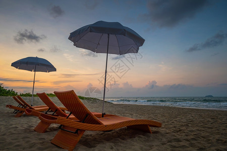 沙滩上橙色椅和遮阳伞图片