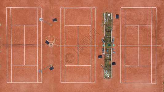 商业休闲的游戏空中观光无人机在网球场3个操上向顶部每天用泥土玩耍没有人空无一图片