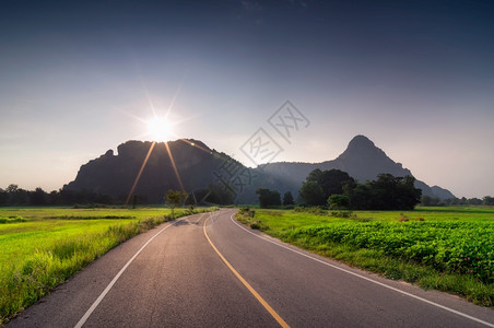 运输晚上太阳山谷的美丽道路与温暖的夜晚照明通向山上的公路图片