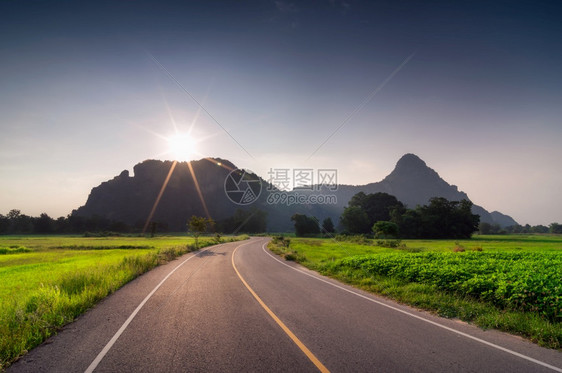 运输晚上太阳山谷的美丽道路与温暖的夜晚照明通向山上的公路图片