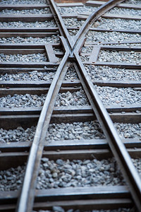 铁轨由钢制成放置在一块木头上石板地很小行业叉火车图片