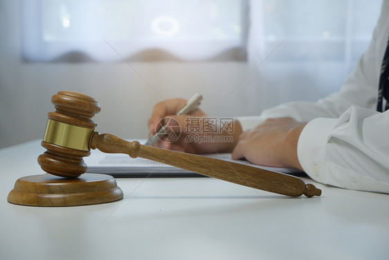 正义木槌法官在律师服务台上敲锤木制的图片