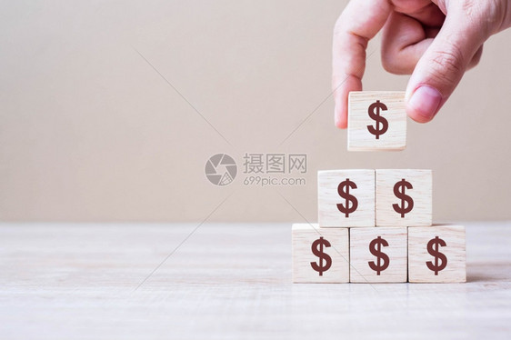 制造支付债券商人手握木制块印有美元符号货币现金和投资概念的纸币货和投资概念图片