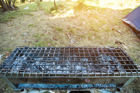 野餐空白的关闭木炭炉火在森林的营地用钢铁火炉烧煤炭晚餐图片