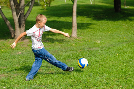 运动脚丫子小男孩在野外的草地上玩球可爱的图片