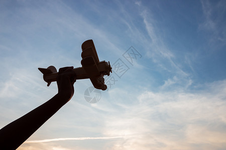 保持喜悦在日落的天空背景下玩木具飞机的快乐孩子休眠阴影图片