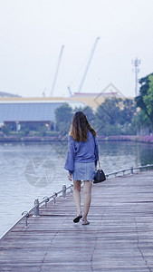 旅行自由妇女在木桥上行走背部图片