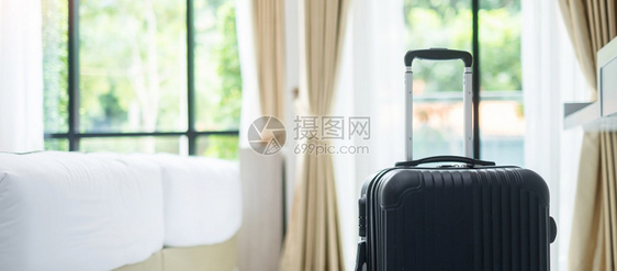 休息现代旅馆房间的黑色行李有窗户帘和绿色自然背景床面的绿窗帘旅行放松和休假概念时间酒店图片