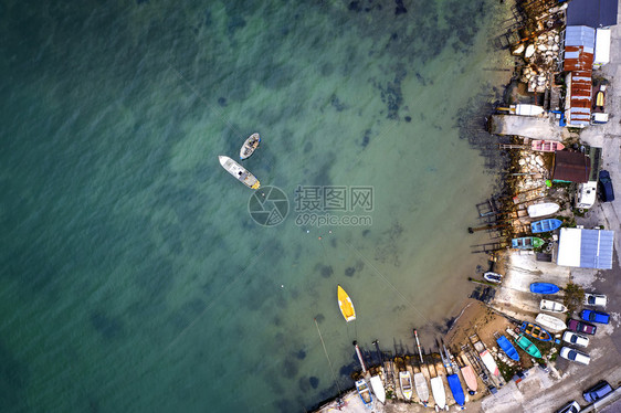 海浪从无人驾驶飞机到码头和船坞的顶端风景船上有只和游艇海景观上面有捕鱼房屋户外绿松石图片