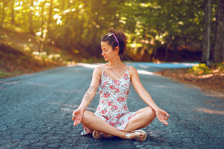 女穿着暑期服装的年轻女青坐在林路上露珠瑜伽在和平中冥想衡精神和自然概念中的沉思姿势成人图片