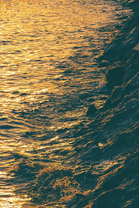 景观在海面上反射美丽的金色阳光在日落时沿海滩竖立垂直架状堆积岩石支撑时间图片