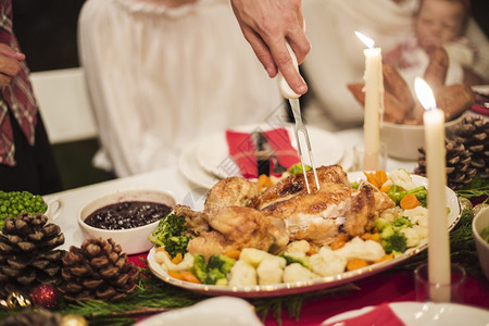 家庭明亮的手持火鸡有叉子圣诞节桌展示图片