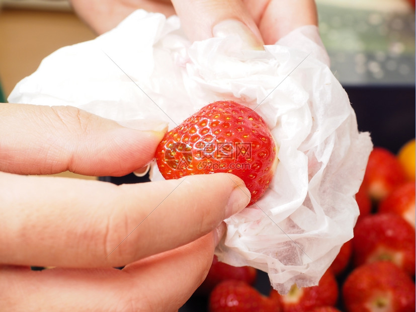 水果食物厨师女用白家纸擦干洗过的草莓和白家用纸图片