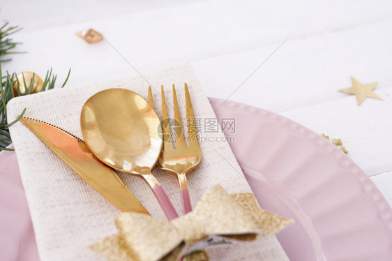 粉色的叉设置板圣诞桌金弓餐具圆形树枝和星桌布图片