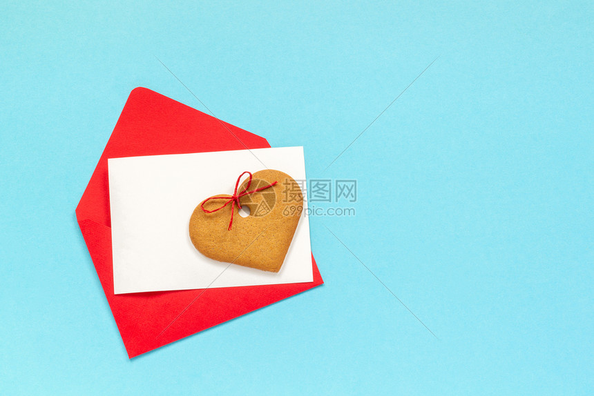问候信息成形红封空白纸卡用于文字和心形姜饼干放在蓝背景上翻版空间错装用爱的红信封打喜悦黑白纸卡放在蓝背景上图片