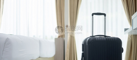 旅游包酒店现代馆房间的黑色行李有窗户帘和床幕及底背景旅行放松和休假概念的时间图片