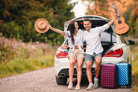 自然女士年青夫妇旅行者坐在汽车的后备箱中度暑假享受的旅游者是年青夫妇驾驶图片