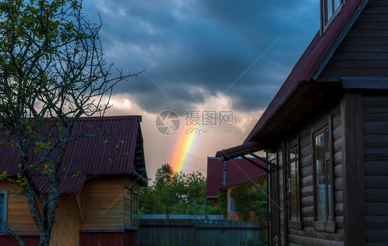 丰富多彩的美丽雨后虹在天空中风暴发生之后彩虹在天空中自然效应在雷暴之后太阳图片