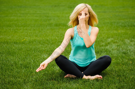 手自然采取绿草的金子女人做瑜伽冥想图片