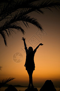 暮日落时在热带海滩棕榈树旁的一位放松女人休眠美丽田园诗般图片
