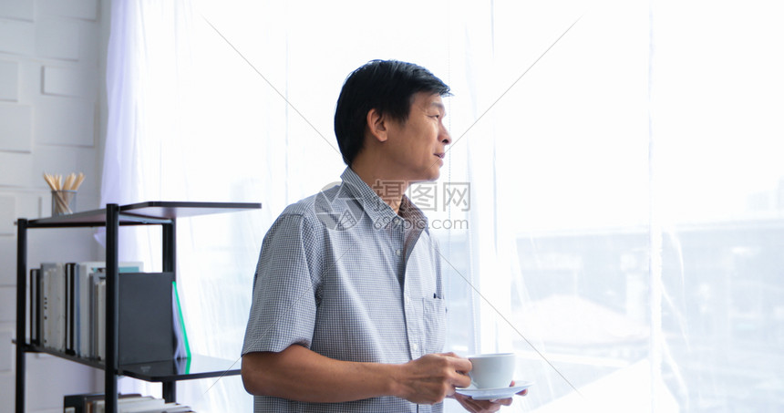 白种人喜爱快乐的高年亚裔男子在休息时间喝咖啡图片