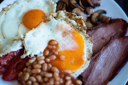 满的传统英语早餐炸培根蘑菇鸡蛋烤面包和番茄五花胖的图片