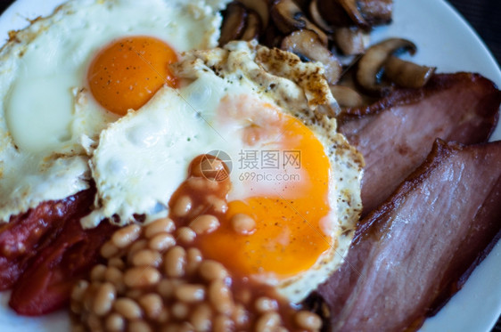 满的传统英语早餐炸培根蘑菇鸡蛋烤面包和番茄五花胖的图片