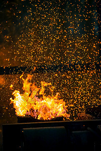 燃烧薄片深暗抽象背景的火焰和花与bokeh热图片