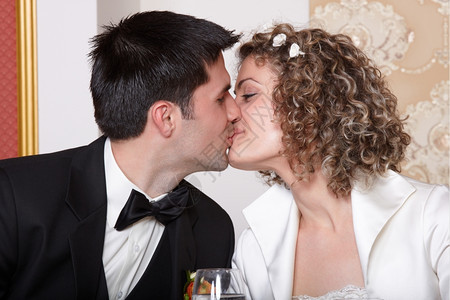 喜悦桌子美丽新娘和郎在婚礼桌上接吻图片